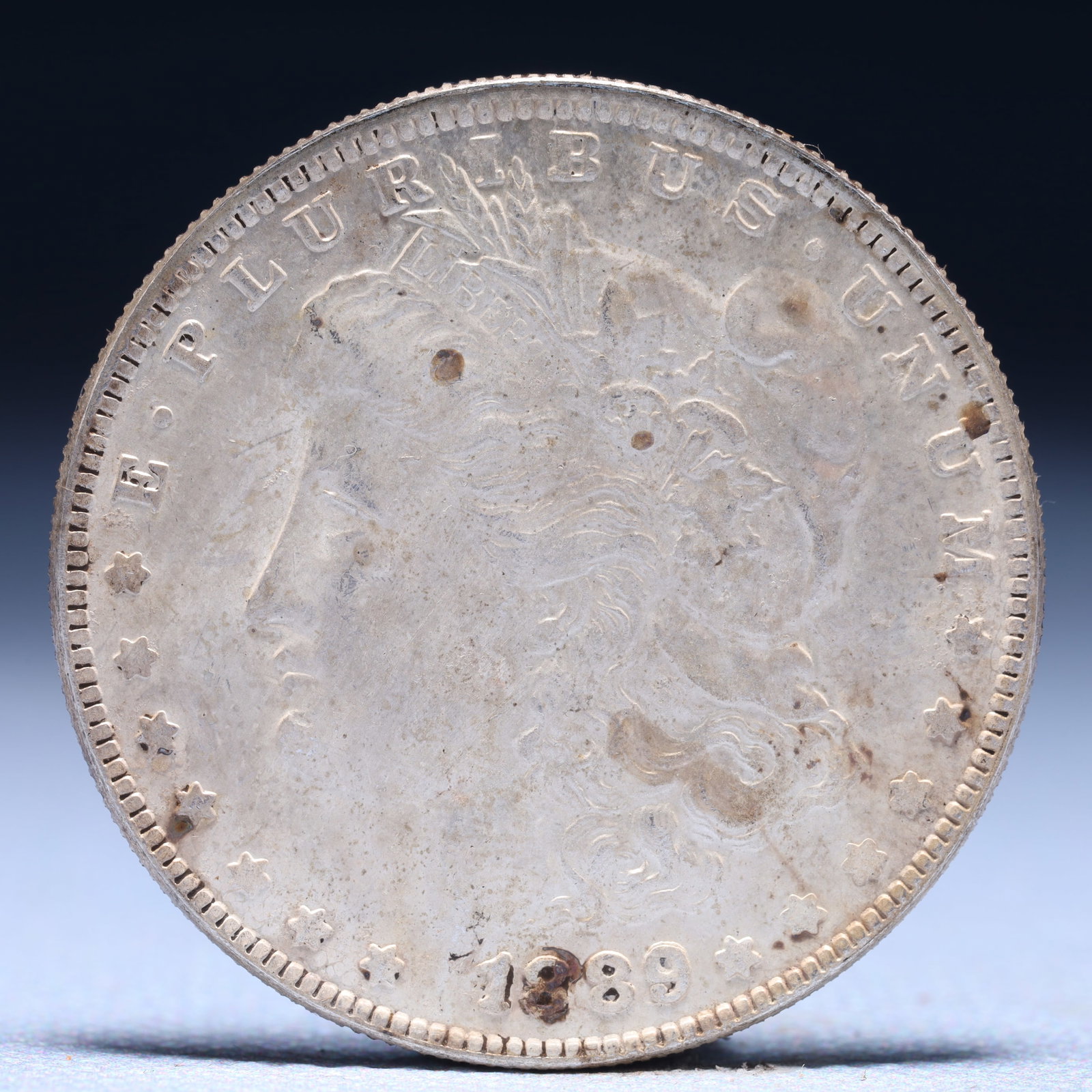 USA Morgan Dollar 1889 Coin: Obv: profile bust with date below and E PLURIBUS UNUM legend and stars around. Rev: eagle with In God we trust above within wreath with UNITED STATES OF AMERICA ONE DOLLAR legend. IN GOD WE TRUST / LI