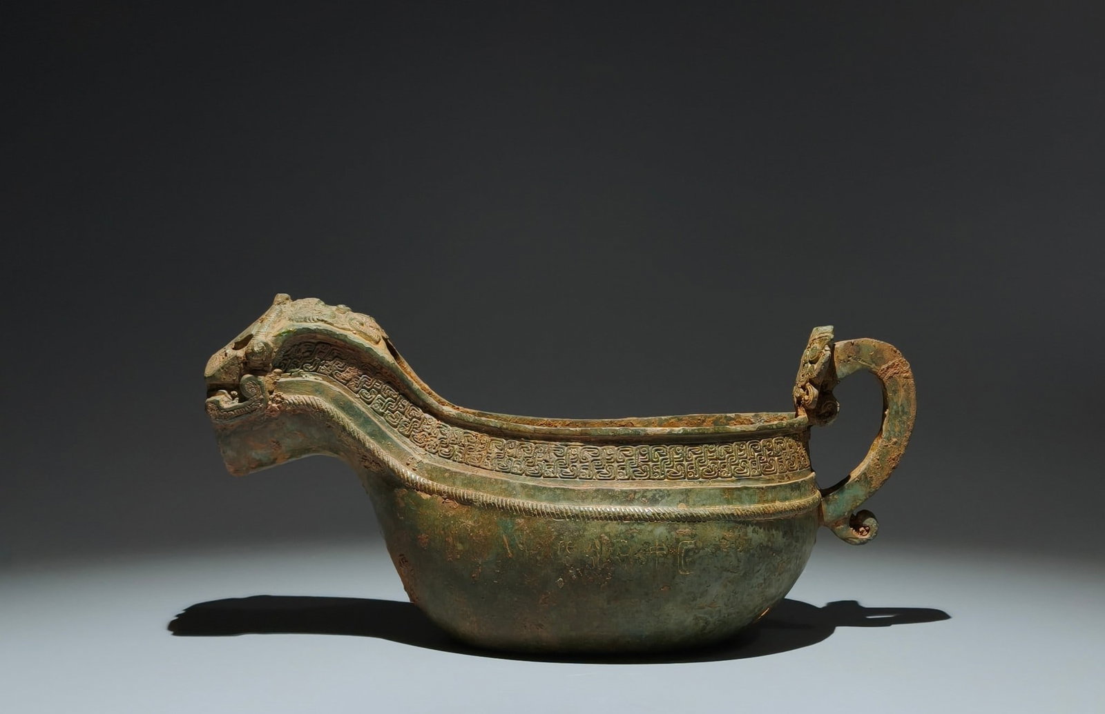 An Archaic Bronze Thunder and Cloud Pattern Beast-head Cup,With Inscription: An Archaic Bronze Thunder and Cloud Pattern Beast-head Cup,With Inscription,the Spring and Autumn in Period in China,Size:6.3inx13inx5.5in 青铜云雷纹兽首Ĉ
