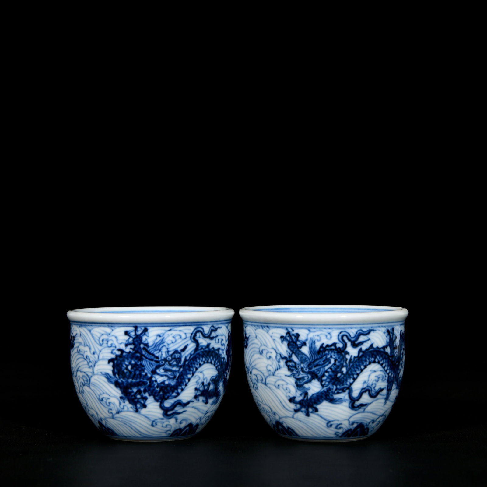 A Pair of Exquisite Blue and White Seawater and Dragon Pattern Cups: A Pair of Exquisite Blue and White Seawater and Dragon Pattern Cups,Ming Dynasty, China,Xuande Six-character Mark,Size:2.2inx3in 一对青花海水龙纹杯