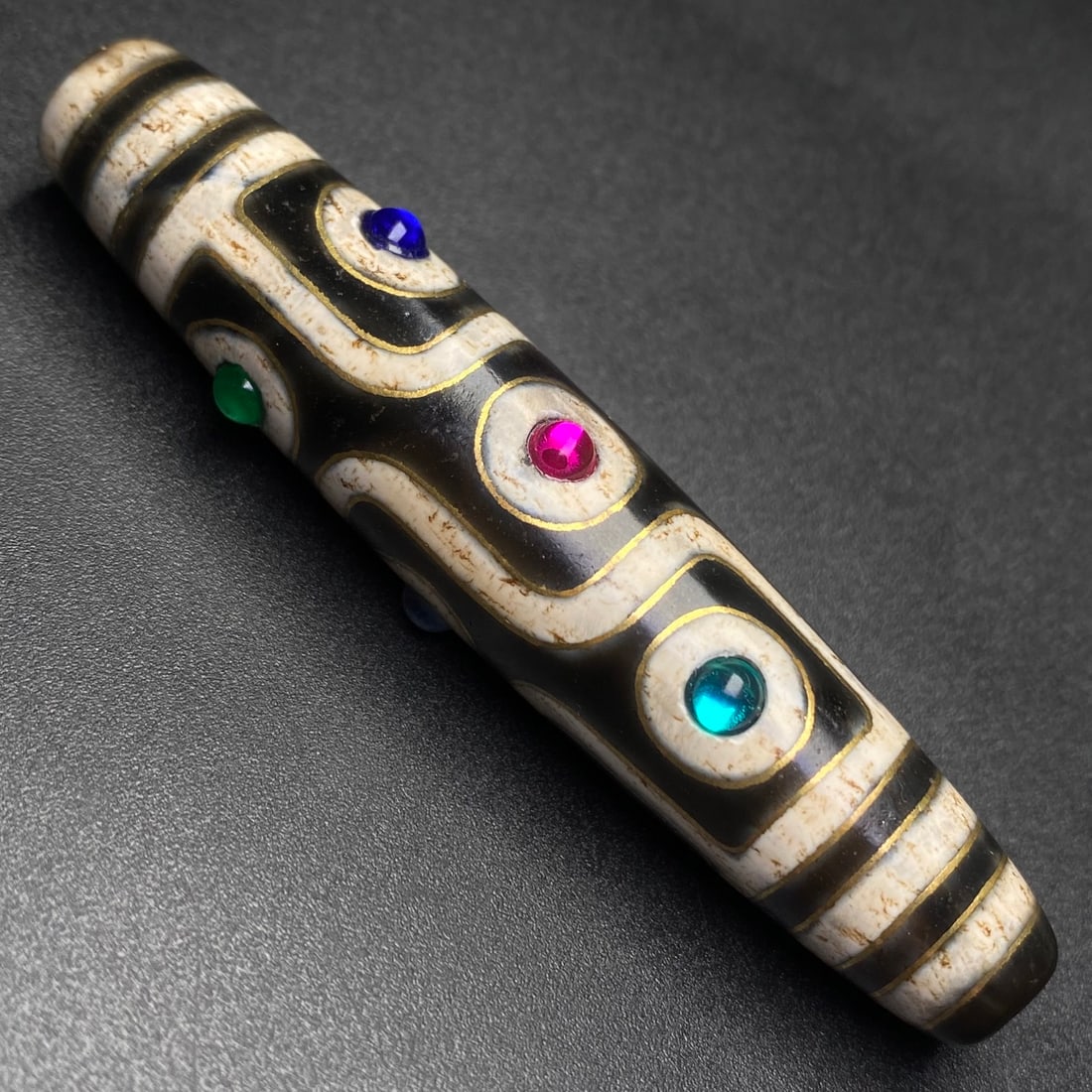 An Exquisite Nine Eyes Dzi Bead Pendant,Inlaid Gold wire,Inlaid Gems: An Exquisite Nine Eyes Dzi Bead Pendant,Inlaid Gold wire,Inlaid Gems,Size:75mmx15mm,Weight:26.3g 九眼天珠挂件,嵌金丝,嵌宝石