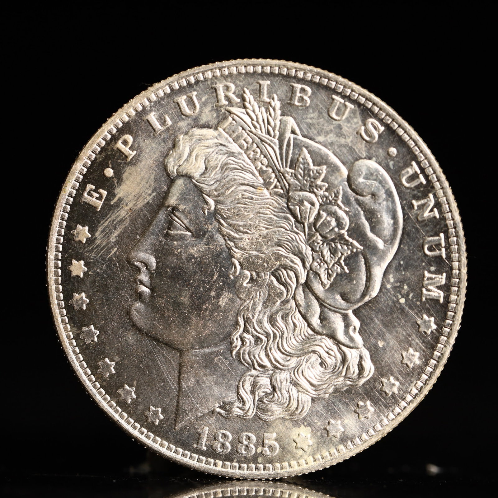 USA Morgan Dollar 1885 Coin: Obv: profile bust with date below and E PLURIBUS UNUM legend and stars around. Rev: eagle with In God we trust above within wreath with UNITED STATES OF AMERICA ONE DOLLAR legend. IN GOD WE TRUST / LI