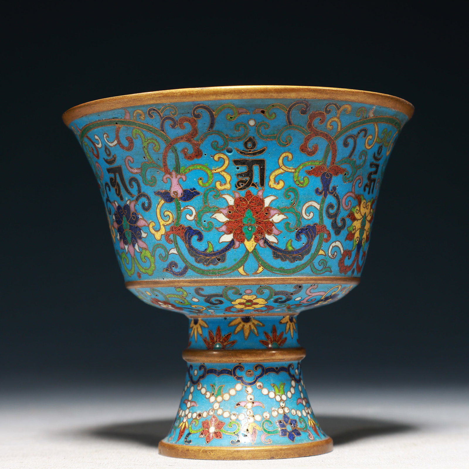 An Exquisite Cloisonne Lotus Pattern Stem Cup,With Sanskrit: An Exquisite Cloisonne Lotus Pattern Stem Cup,With Sanskrit,Qing Dynasty,China,Qianlong Four-character Mark,Size:5.1inx4.9in,Weight:650g 景泰蓝缠枝莲纹高