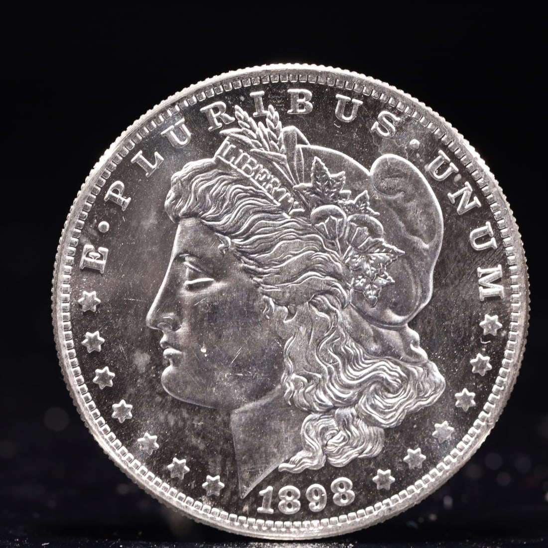 USA Morgan Dollar 1898 Coin: Obv: profile bust with date below and E PLURIBUS UNUM legend and stars around. Rev: eagle with In God we trust above within wreath with UNITED STATES OF AMERICA ONE DOLLAR legend. IN GOD WE TRUST / LI