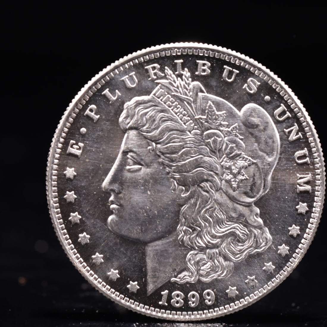 USA Morgan Dollar 1899 Coin: Obv: profile bust with date below and E PLURIBUS UNUM legend and stars around. Rev: eagle with In God we trust above within wreath with UNITED STATES OF AMERICA ONE DOLLAR legend. IN GOD WE TRUST / LI