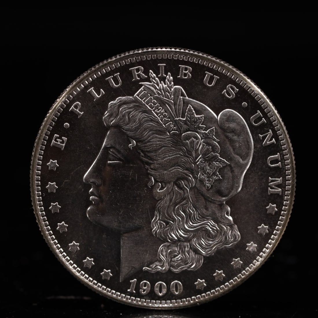 USA Morgan Dollar 1900 Coin: Obv: profile bust with date below and E PLURIBUS UNUM legend and stars around. Rev: eagle with In God we trust above within wreath with UNITED STATES OF AMERICA ONE DOLLAR legend. IN GOD WE TRUST /