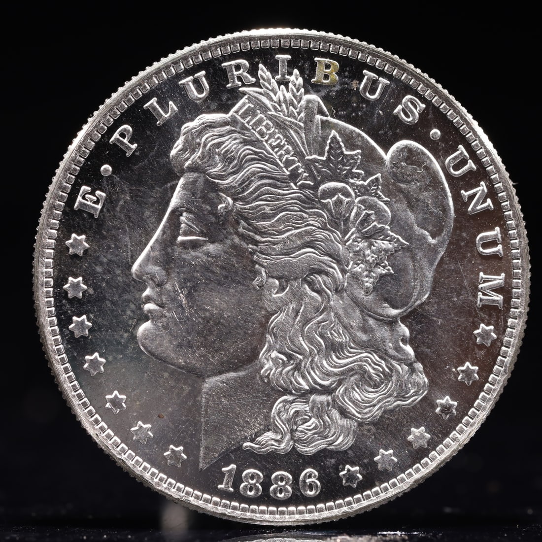 USA Morgan Dollar 1886 Coin: Obv: profile bust with date below and E PLURIBUS UNUM legend and stars around. Rev: eagle with In God we trust above within wreath with UNITED STATES OF AMERICA ONE DOLLAR legend. IN GOD WE TRUST / LI