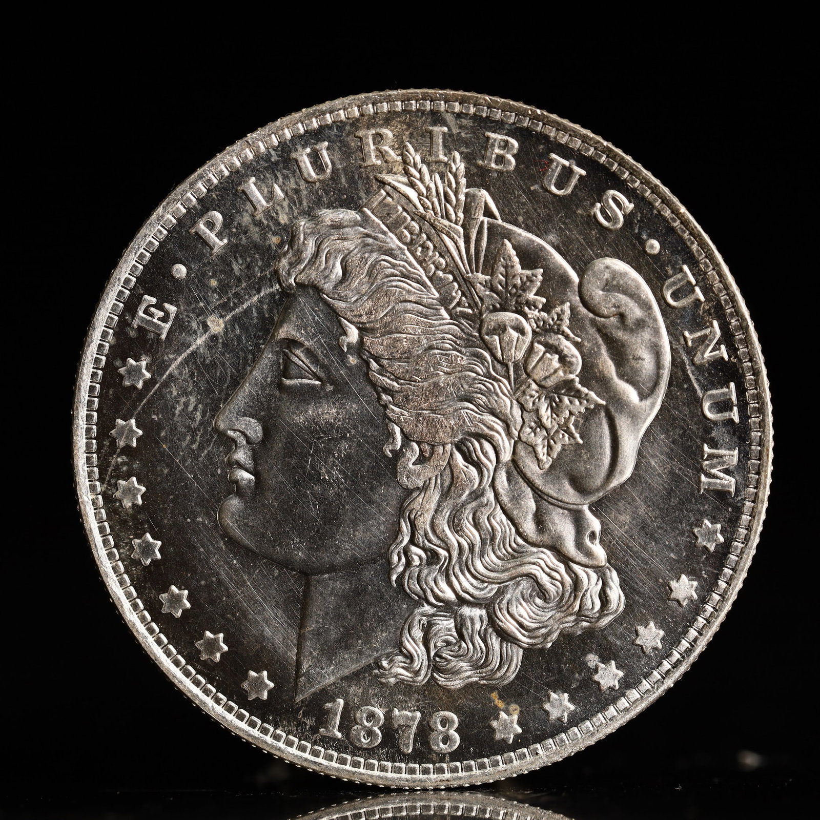 USA Morgan Dollar 1878 Coin: Obv: profile bust with date below and E PLURIBUS UNUM legend and stars around. Rev: eagle with In God we trust above within wreath with UNITED STATES OF AMERICA ONE DOLLAR legend. IN GOD WE TRUST /