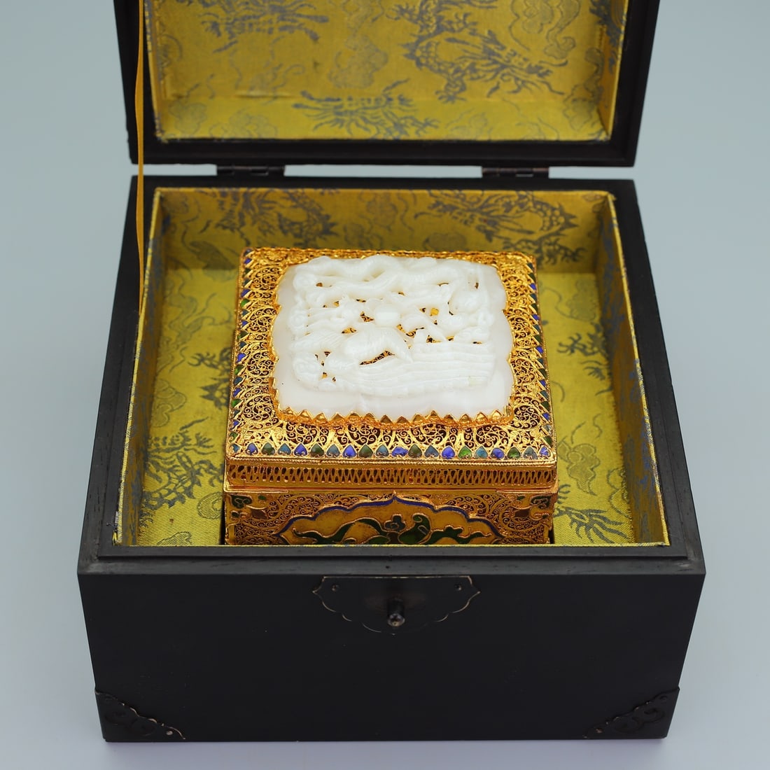 An Exquisite Gilt Bronze Inlaid White Jade Dragon and Phoenix Pattern Box: An Exquisite Gilt Bronze Inlaid White Jade Dragon and Phoenix Pattern Box Qing Dynasty, China Qianlong Four-character Mark Size:5.5inx8.7in Weight:1835g Size:3.1inx4.7in
