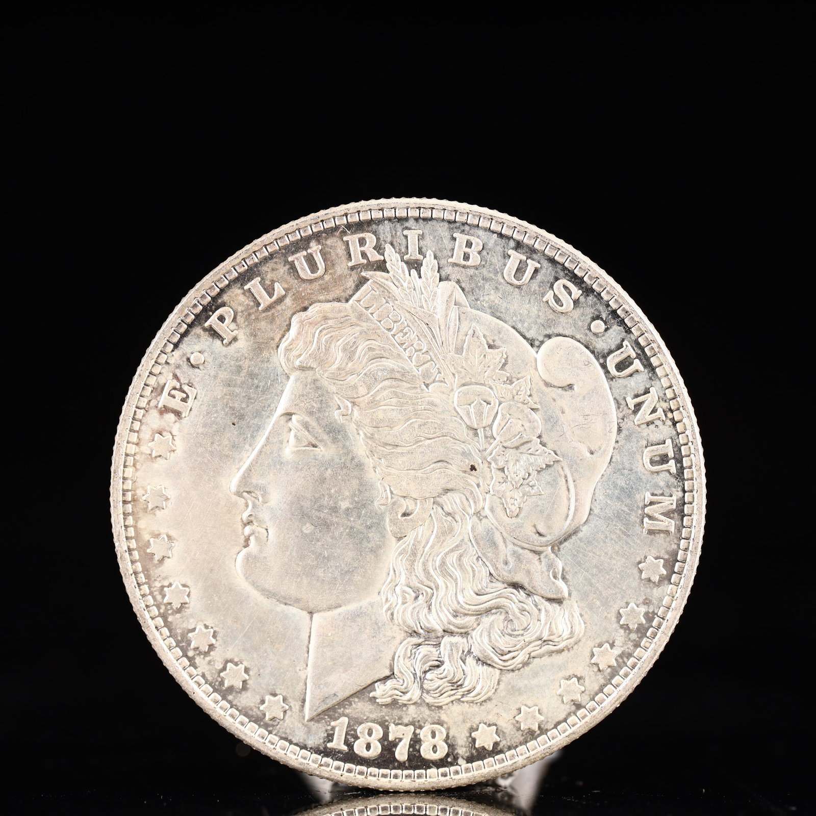 USA Morgan Dollar 1878 Coin: Obv: profile bust with date below and E PLURIBUS UNUM legend and stars around. Rev: eagle with In God we trust above within wreath with UNITED STATES OF AMERICA ONE DOLLAR legend. IN GOD WE TRUST /