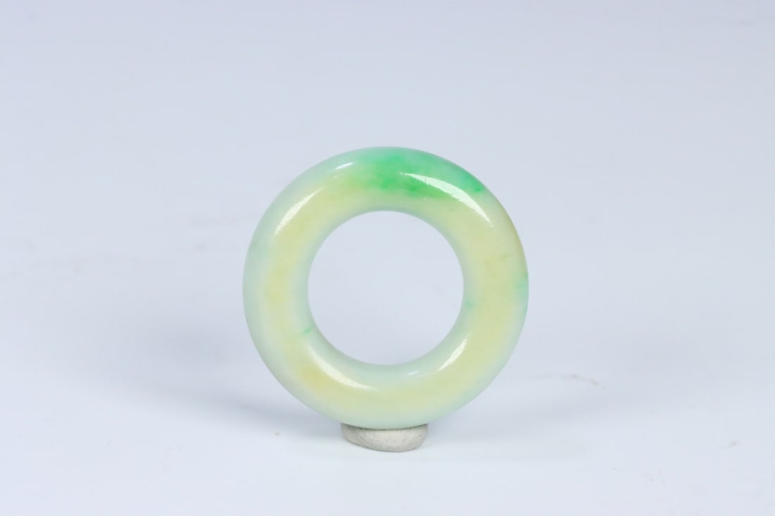 An Exquisite Jadeite Pendant: An Exquisite Jadeite Pendant Qing Dynasty, China Size:1.3inx0.7inx0.3in Weight:12g翡翠飘绿素纹袈裟环 中国清代 Size:3.23cmx