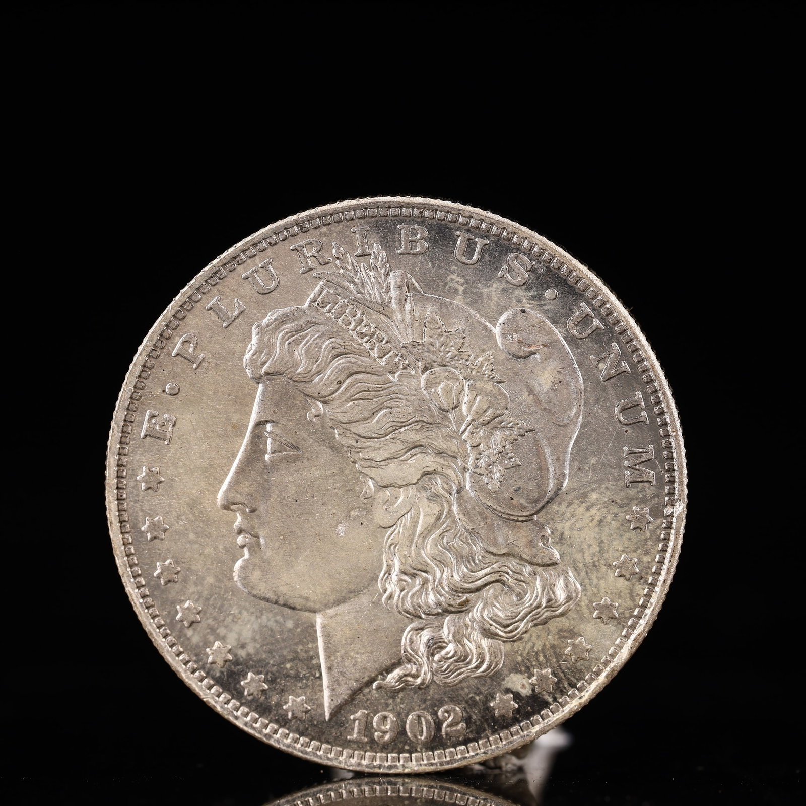 USA Morgan Dollar 1902 Coin: Obv: profile bust with date below and E PLURIBUS UNUM legend and stars around. Rev: eagle with In God we trust above within wreath with UNITED STATES OF AMERICA ONE DOLLAR legend. IN GOD WE TRUST /