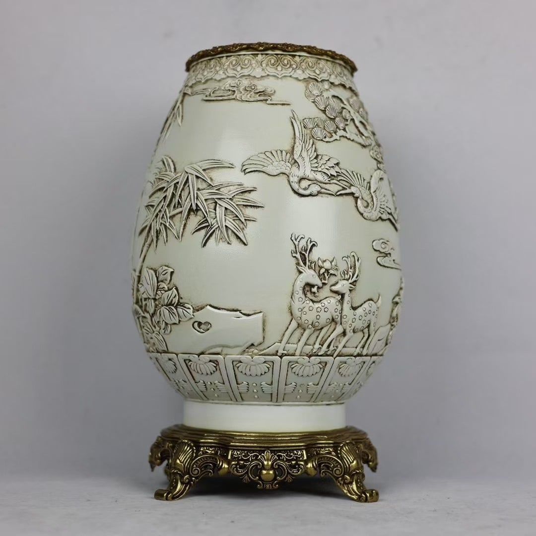 An Exquisite White Glaze Inlaid Bronze Pine and Crane Pattern Vase: An Exquisite White Glaze Inlaid Bronze Pine and Crane Pattern Vase Qing Dynasty, China Size:13.8inx8.3in白釉鹤鹿同春镶铜边福筒