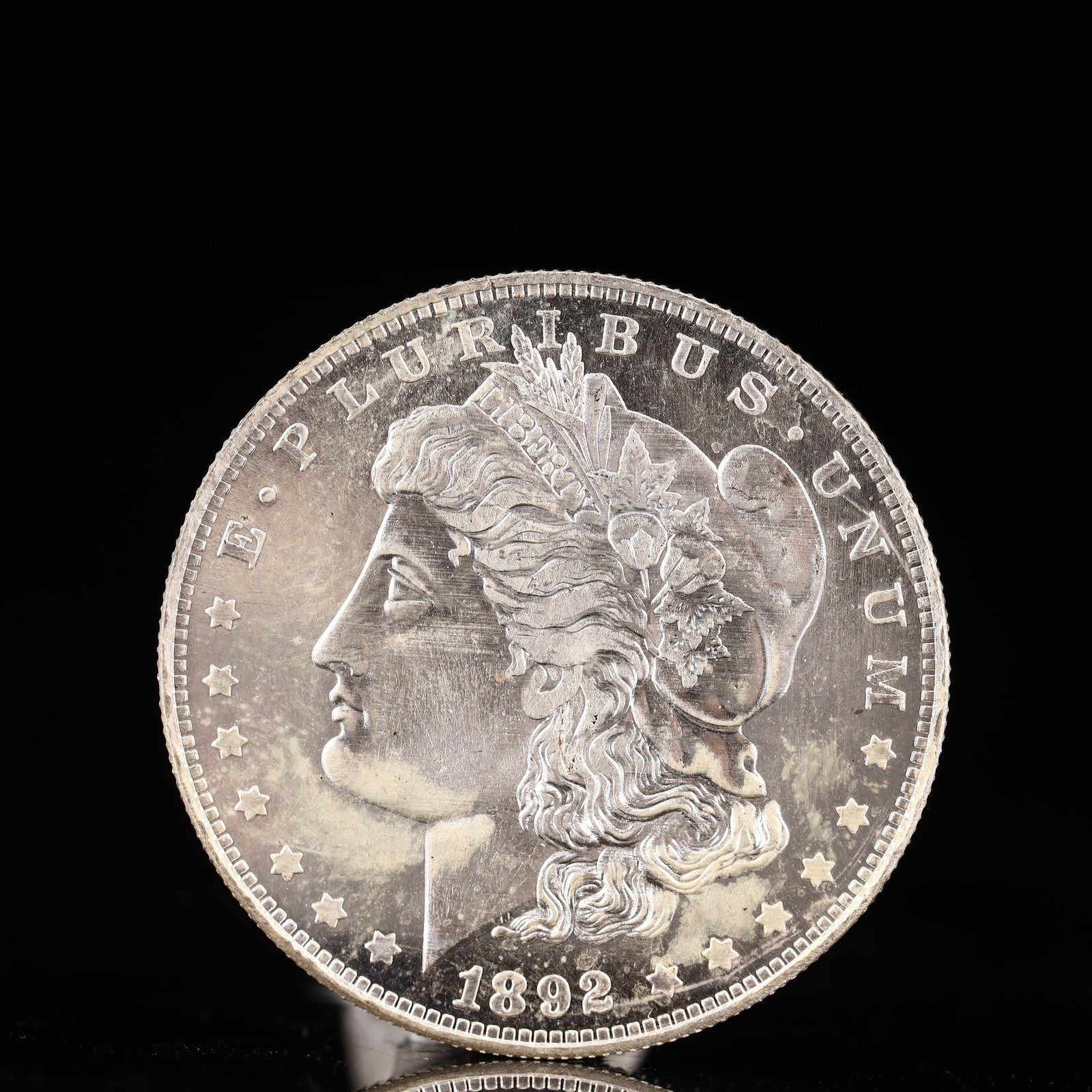 USA Morgan Dollar 1892 Coin: Obv: profile bust with date below and E PLURIBUS UNUM legend and stars around. Rev: eagle with In God we trust above within wreath with UNITED STATES OF AMERICA ONE DOLLAR legend. IN GOD WE TRUST / LI