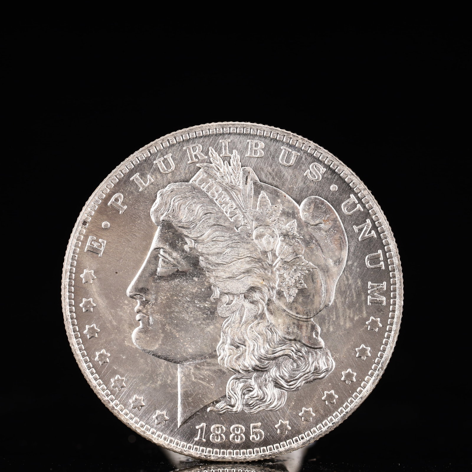 USA Morgan Dollar 1885 Coin: Obv: profile bust with date below and E PLURIBUS UNUM legend and stars around. Rev: eagle with In God we trust above within wreath with UNITED STATES OF AMERICA ONE DOLLAR legend. IN GOD WE TRUST / LI