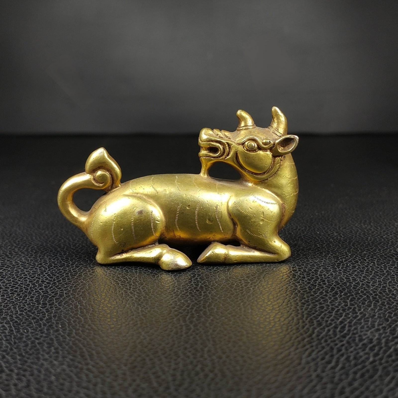 An Exquisite Gilt Bronze Auspicious Beast Paper Weight: An Exquisite Gilt Bronze Auspicious Beast Paper Weight Han Dynasty, China Size:2inx3.1in Weight:354g铜鎏金卧牛瑞兽镇器