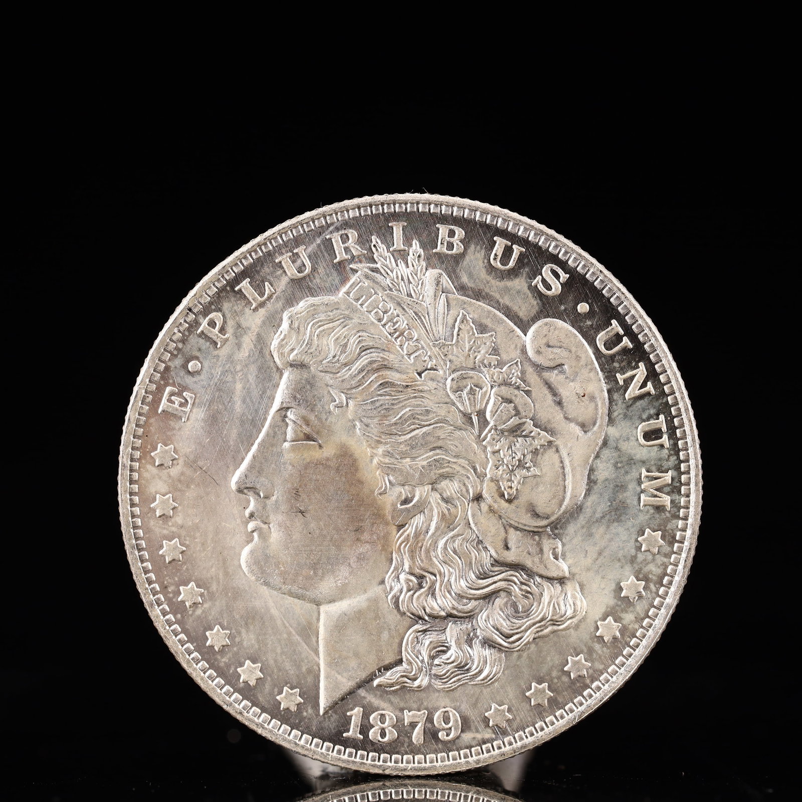 USA Morgan Dollar 1879 Coin: Obv: profile bust with date below and E PLURIBUS UNUM legend and stars around. Rev: eagle with In God we trust above within wreath with UNITED STATES OF AMERICA ONE DOLLAR legend. IN GOD WE TRUST /