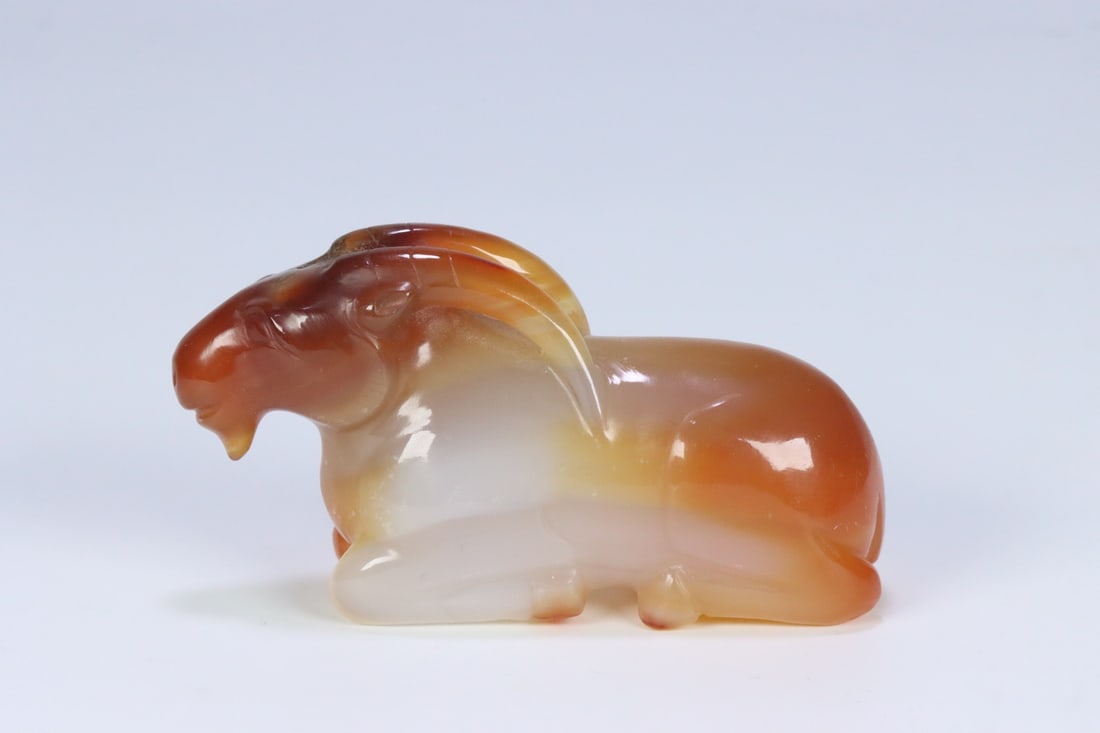 An Exquisite Agate Sheep Hand Piece: An Exquisite Agate Sheep Hand Piece Qing Dynasty, China Size:3.4inx1.1inx1.8in Weight:132.6g玛瑙卧羊把件 中国清代 Size:8.66cmx2.81cmx4.53cm
