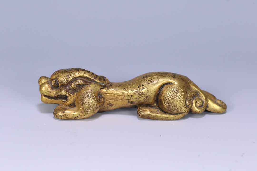 An Exquisite Gilt Bronze Auspicious Beast Ornament: An Exquisite Gilt Bronze Auspicious Beast Ornament Qing Dynasty, China Size:5.1inx1.6inx1.1in Weight:186g铜鎏金瑞兽摆件 中国清代
