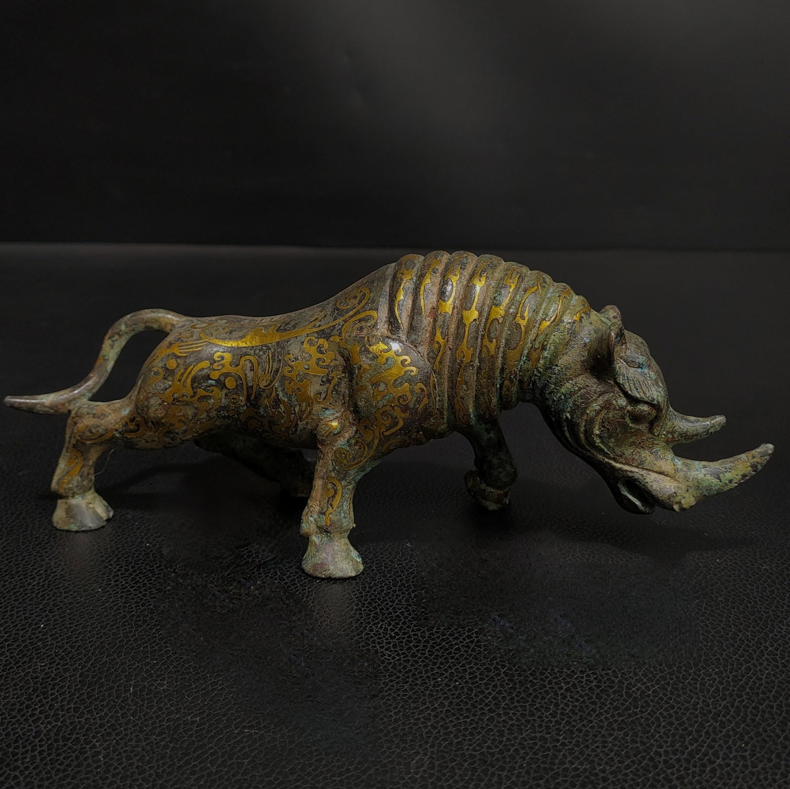 An Exquisite Bronze Inlaid Gold Rhinoceros Ornament: An Exquisite Bronze Inlaid Gold Rhinoceros Ornament the Warring States period in China Size:7.5inx2.4inx3.5in Weight:0.7kg错金青铜犀牛摆件 战Þ