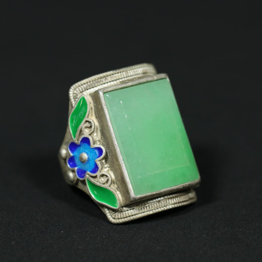 An Exquisite Silver Inlaid Jadeite Ring: An Exquisite Silver Inlaid Jadeite Ring Qing Dynasty, China Size:1.1inx1.1inx1in Size:(inside diameter)0.8in Weight:22.5g银烧蓝镶嵌翡翠戒指
