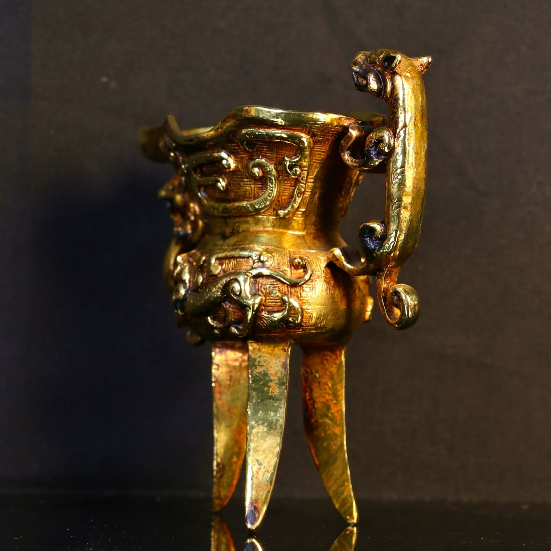 A Exquisite Gilt Bronze Tripod Auspicious Beast Goblet: A Exquisite Gilt Bronze Tripod Auspicious Beast Goblet,Ming Dynasty, China,Size:4.3inx5.3in,Weight:600g 铜鎏金三足瑞兽爵杯,中国明