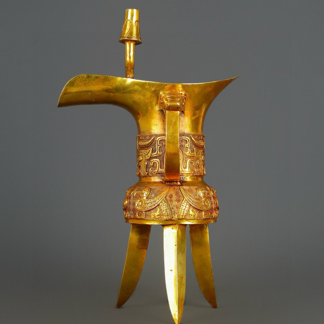 An Exquisite Gilt Bronze Tripod Goblet: An Exquisite Gilt Bronze Tripod Goblet Han Dynasty, China Size:10.2inx16.9in Weight:2500g铜鎏金三足爵杯 中国汉代 Size:26cmx43cm Weight