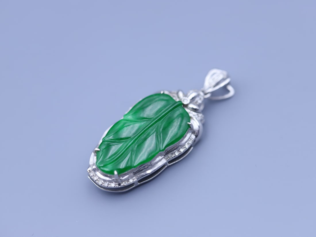 An Exquisite Jadeite Silver-cased Pendant: An Exquisite Jadeite Silver-cased Pendant Qing Dynasty, China Size:1.1inx0.6inx0.2in Weight:2.4g翡翠叶子吊坠高冰包银镶嵌 中