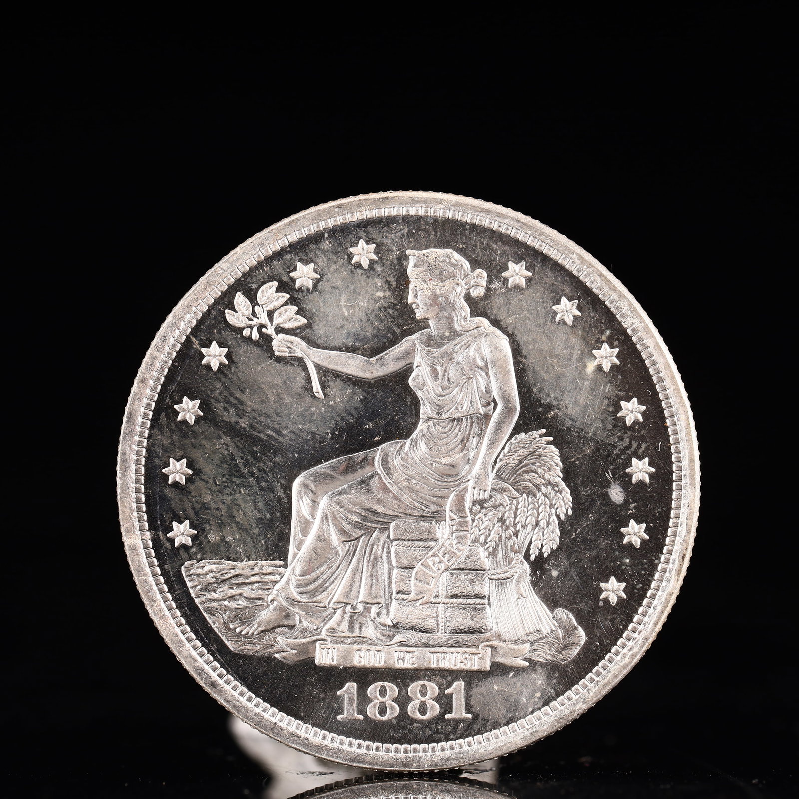 USA Trade Dollar 1881 Coin: American coin. Obverse: Liberty seated on a pedestal facing the sea to the left holding olive branches surrounded by 13 stars. IN GOD WE TRUST / LIBERTY / 1881. Reverse: An eagle holding branches with
