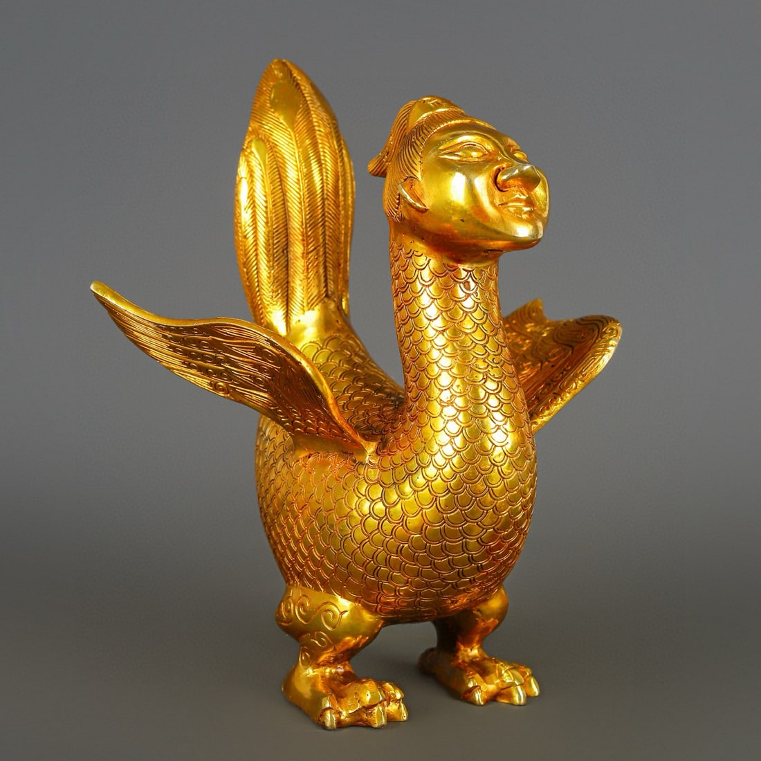 An Exquisite Gilt Bronze Human Face Pattern With Inscription Bird Ornament: An Exquisite Gilt Bronze Human Face Pattern With Inscription Bird Ornament Han Dynasty, China Size:6.7inx10in Weight:2050g铜鎏金人面鸟 中国汉É