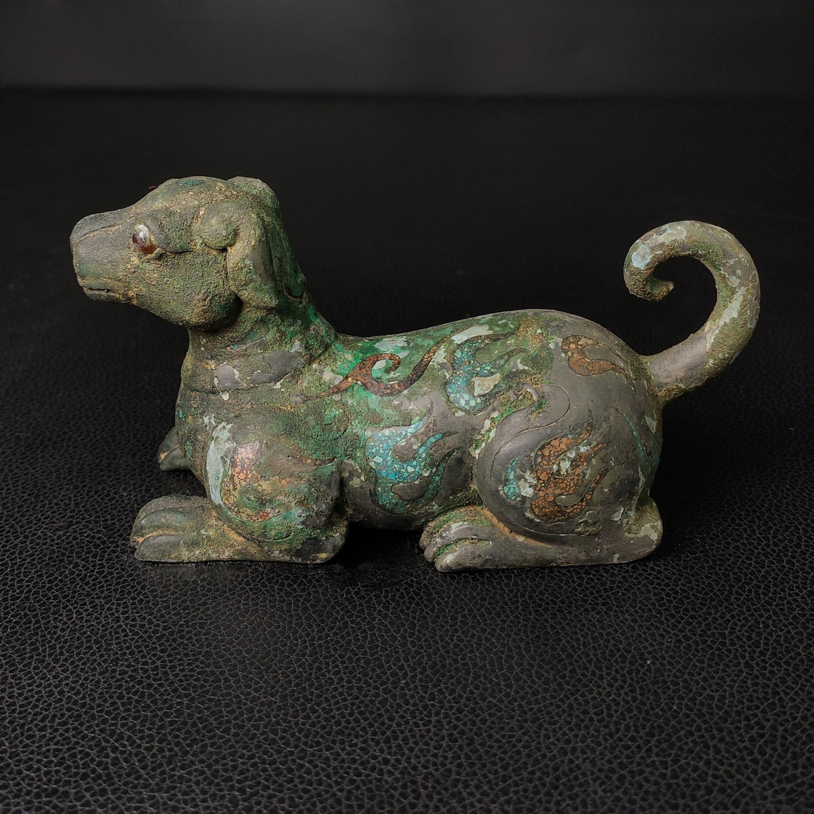 An Exquisite Bronze Dog Ornament: An Exquisite Bronze Dog Ornament the Warring States period in China Size:3.1inx5.5in Weight:0.4kg松石青铜卧犬 战国时期 Size:8cmx14cm Weight: