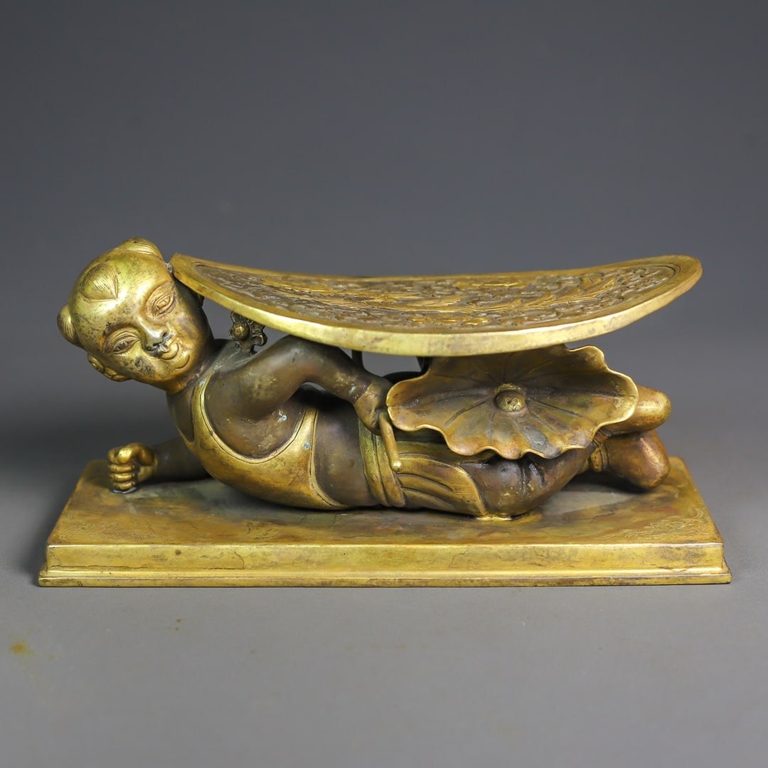 An Exquisite Gilt Bronze Figure-Shaped Pillow: An Exquisite Gilt Bronze Figure-Shaped Pillow Qing Dynasty, China Size:3.9inx7.5in Weight:722g铜鎏金錾刻脉枕 中国清代 Size:10cmx19cm W