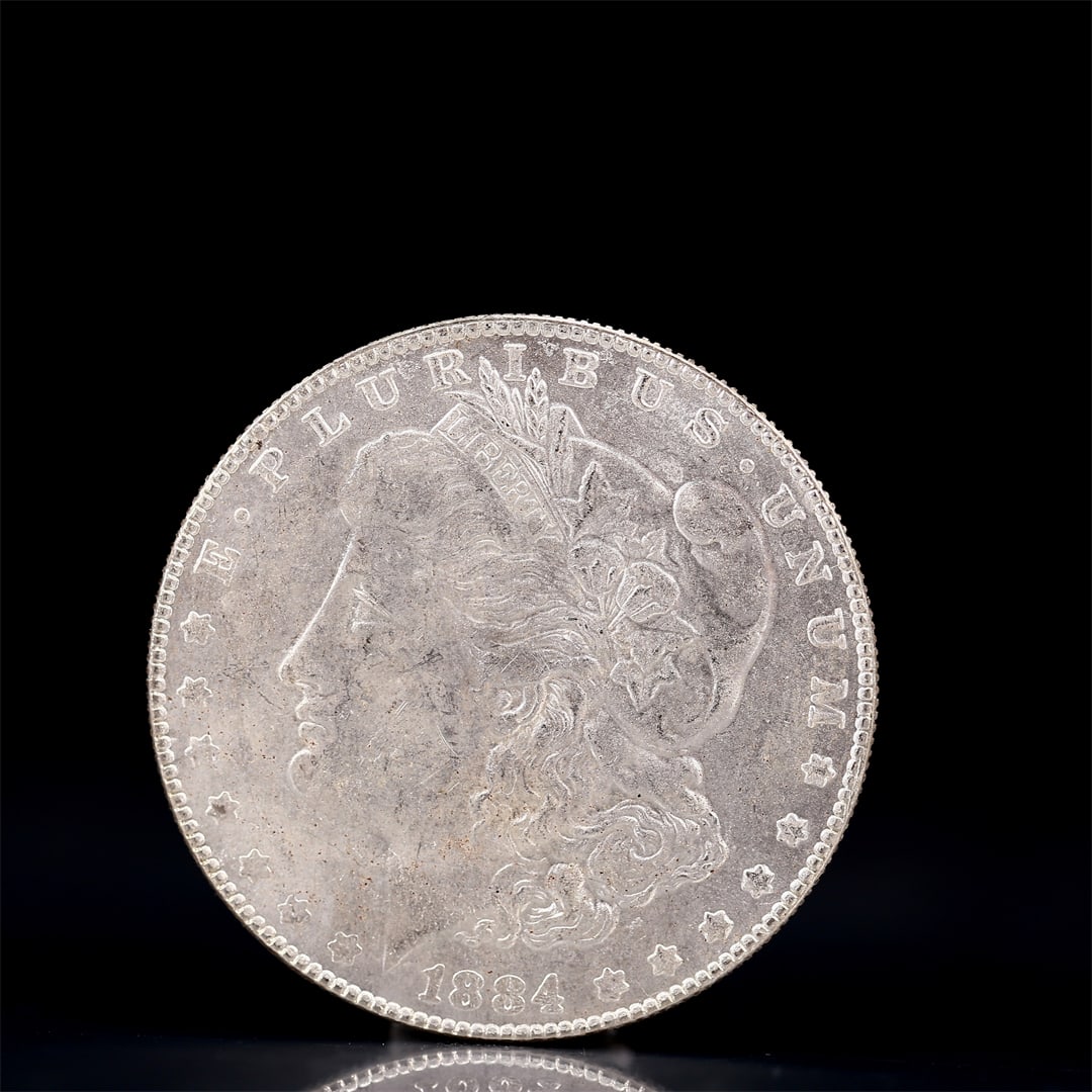 USA Morgan Dollar 1884 Coin: Obv: profile bust with date below and E PLURIBUS UNUM legend and stars around. Rev: eagle with In God we trust above within wreath with UNITED STATES OF AMERICA ONE DOLLAR legend. IN GOD WE TRUST / LI
