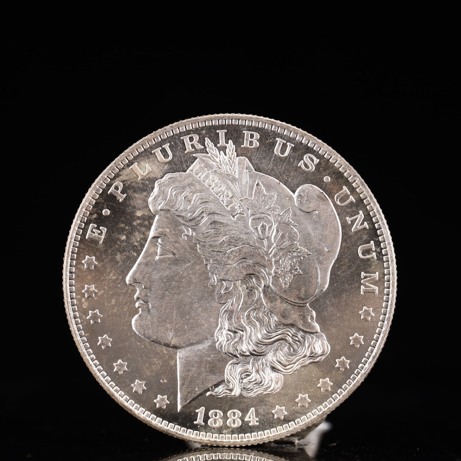 USA Morgan Dollar 1884 Coin: Obv: profile bust with date below and E PLURIBUS UNUM legend and stars around. Rev: eagle with In God we trust above within wreath with UNITED STATES OF AMERICA ONE DOLLAR legend. IN GOD WE TRUST / LI