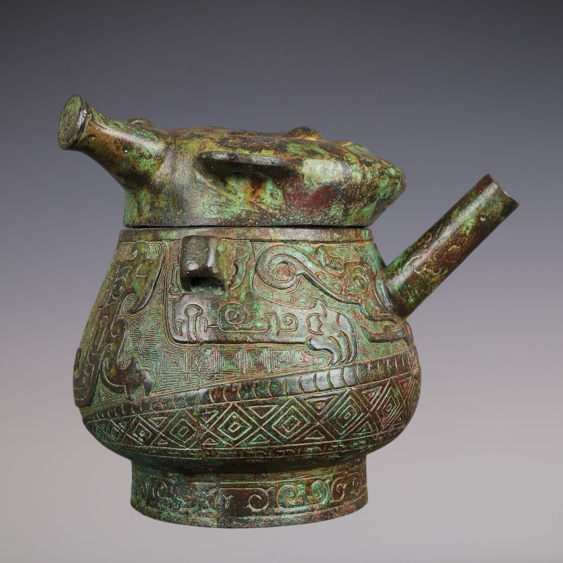An Archaic Bronze Figure-Face Pattern Double-Ears Pot,With Inscription: An Archaic Bronze Figure-Face Pattern Double-Ears Pot,With Inscription,W.Zhou ,China,Size:7.9inx6.7inx7.5in,Weight:2160g青铜人面纹双耳壶,带铭