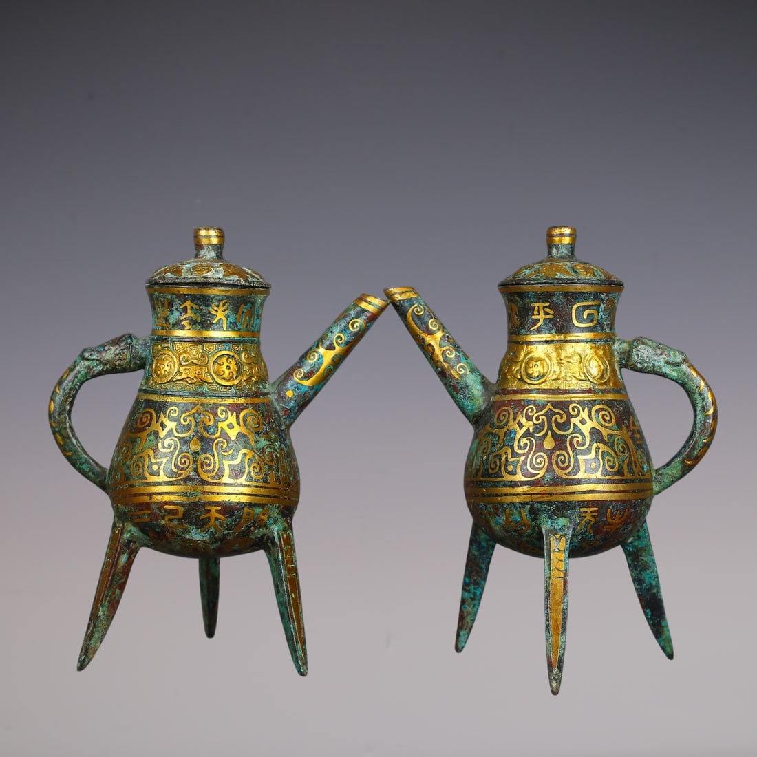 A Pair of Archaic Bronze Inlaid Gold Tripod Flagons,With Inscription: A Pair of Archaic Bronze Inlaid Gold Tripod Flagons,With Inscription,Han Dynasty,China,Size:5.5inx3.3inx7.3in,Total Weight:1090g一对青铜错金三足酒