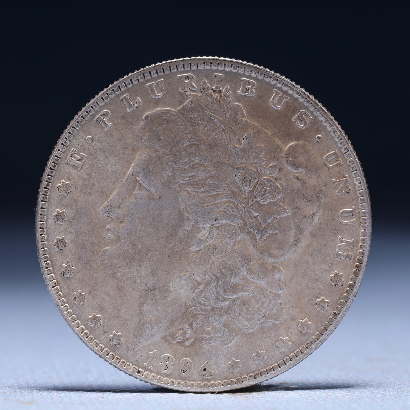 USA Morgan Dollar 1894 Coin: Obv: profile bust with date below and E PLURIBUS UNUM legend and stars around. Rev: eagle with In God we trust above within wreath with UNITED STATES OF AMERICA ONE DOLLAR legend. IN GOD WE TRUST / LI