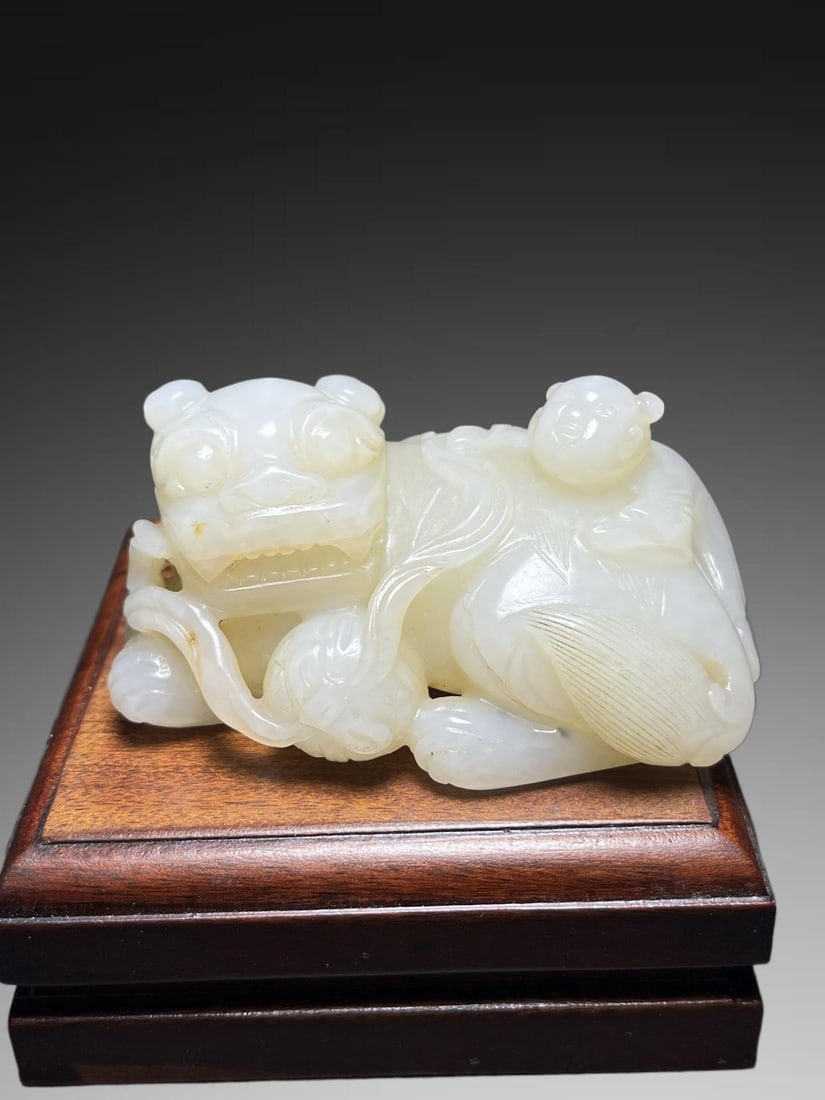 A Exquisite Hotan Jade Lion Handheld Carving: An Exquisite Hotan Jade Lion Handheld Carving,Qing Dynasty, China,Size:2.8inx1.3inx1.7in,Weight:145g 和田玉狮手把件,中国清代