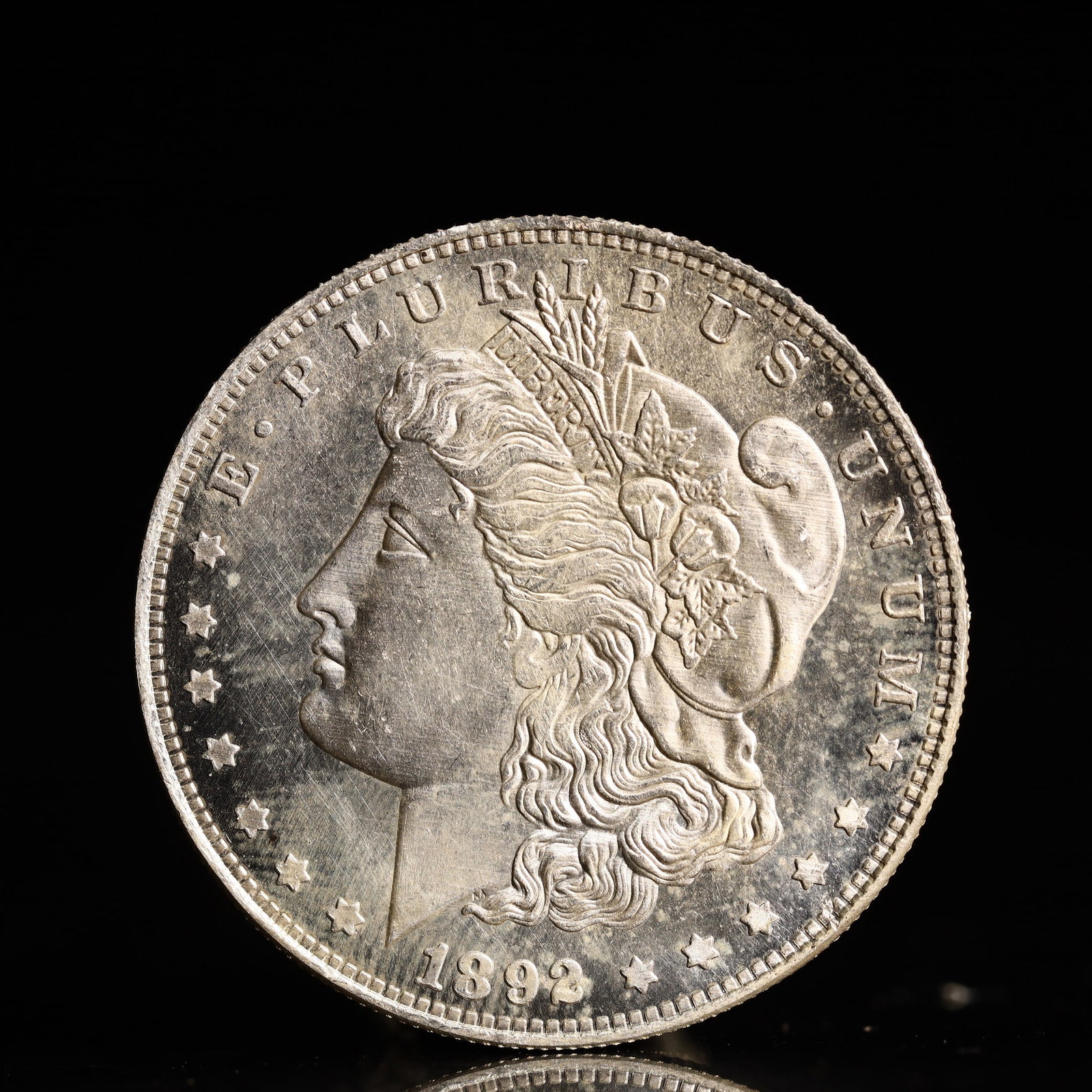 USA Morgan Dollar 1892 Coin: Obv: profile bust with date below and E PLURIBUS UNUM legend and stars around. Rev: eagle with In God we trust above within wreath with UNITED STATES OF AMERICA ONE DOLLAR legend. IN GOD WE TRUST / LI