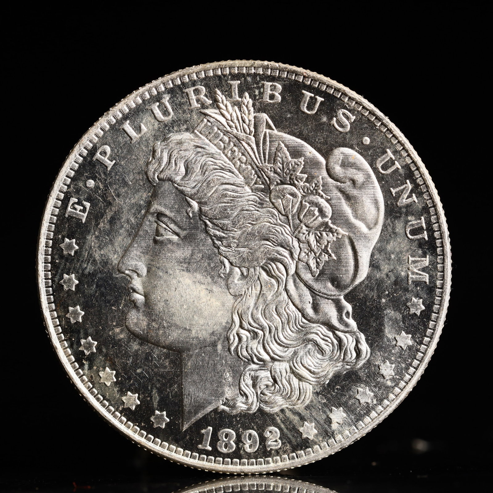 USA Morgan Dollar 1892 Coin: Obv: profile bust with date below and E PLURIBUS UNUM legend and stars around. Rev: eagle with In God we trust above within wreath with UNITED STATES OF AMERICA ONE DOLLAR legend. IN GOD WE TRUST / LI