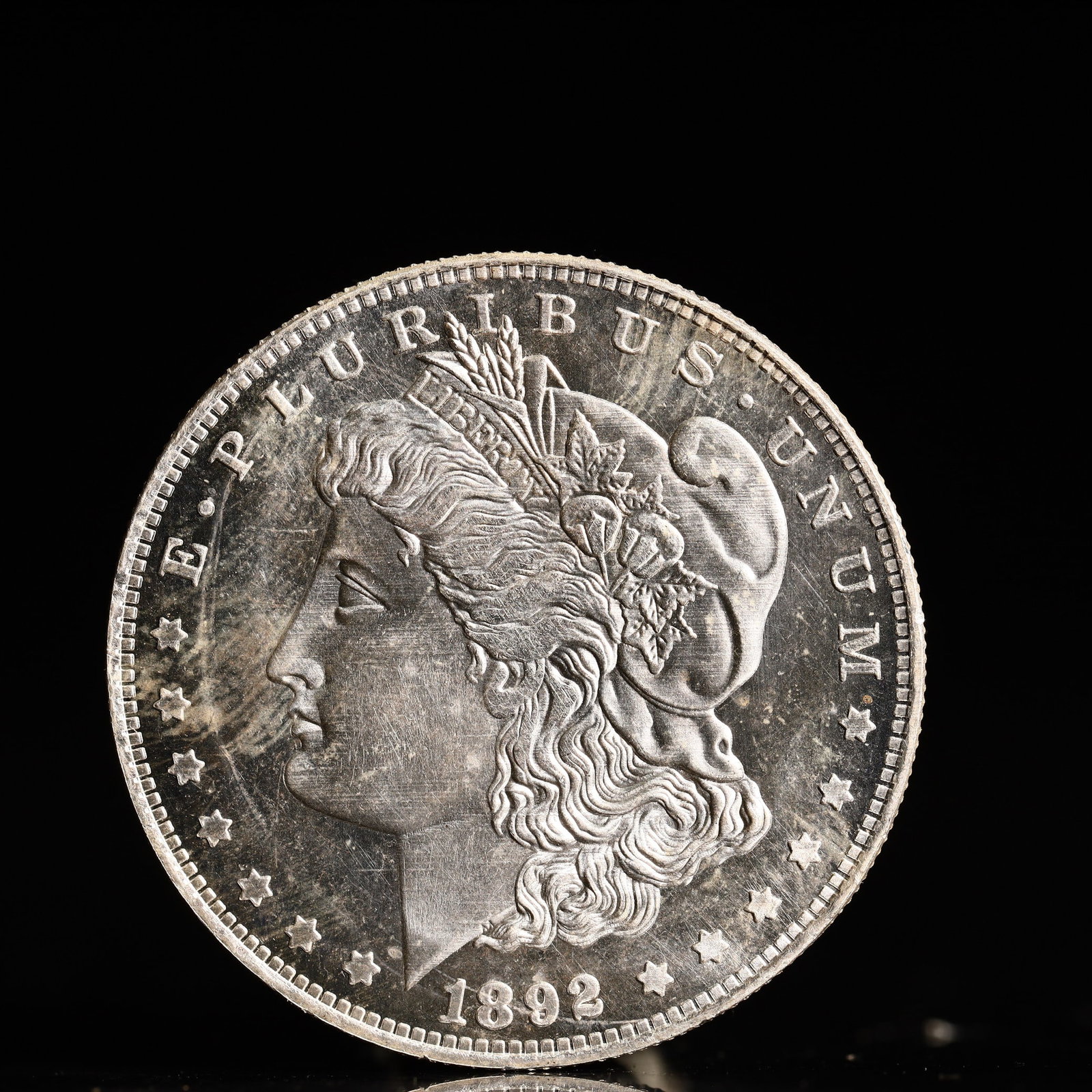 USA Morgan Dollar 1892 Coin: Obv: profile bust with date below and E PLURIBUS UNUM legend and stars around. Rev: eagle with In God we trust above within wreath with UNITED STATES OF AMERICA ONE DOLLAR legend. IN GOD WE TRUST /