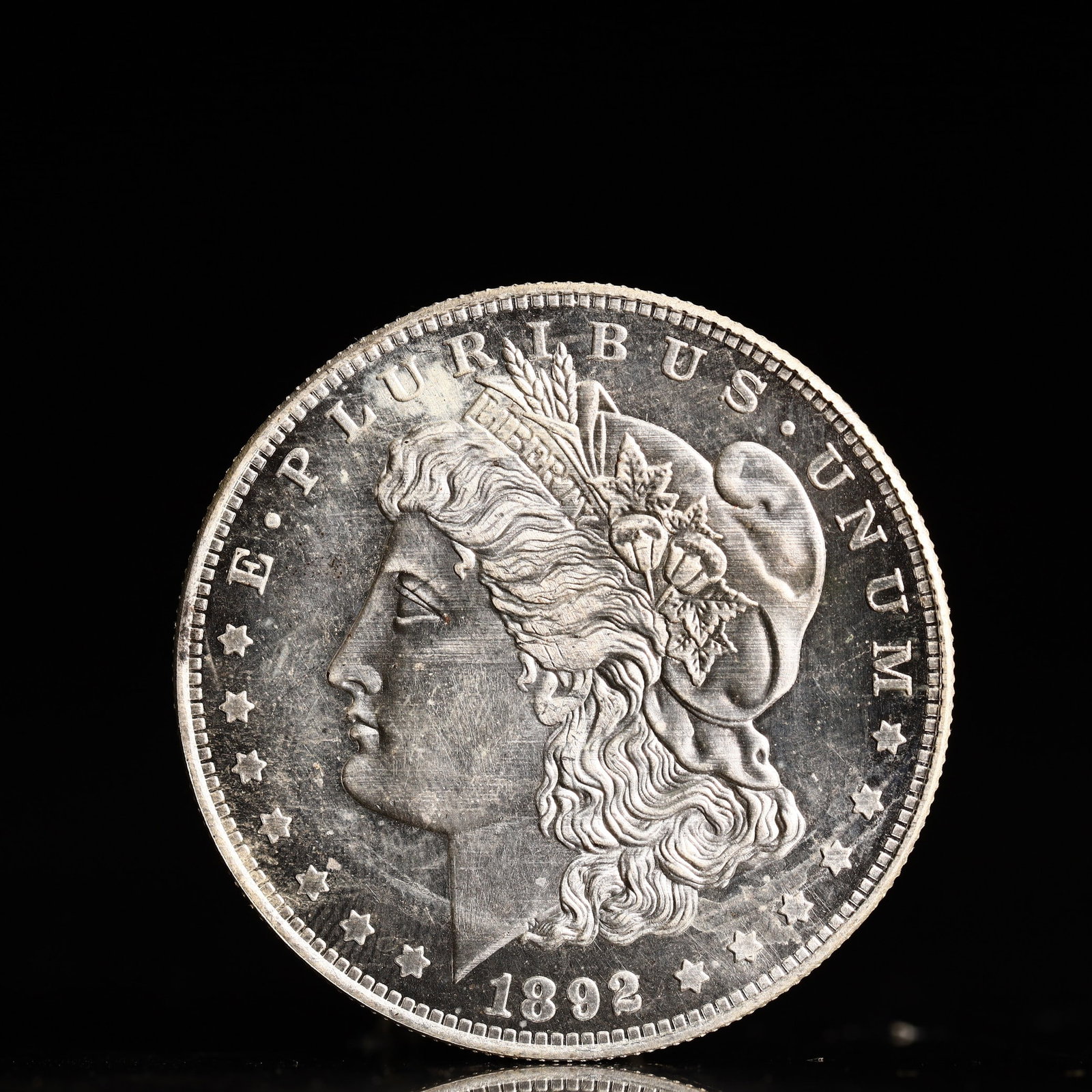USA Morgan Dollar 1892 Coin: Obv: profile bust with date below and E PLURIBUS UNUM legend and stars around. Rev: eagle with In God we trust above within wreath with UNITED STATES OF AMERICA ONE DOLLAR legend. IN GOD WE TRUST / LI