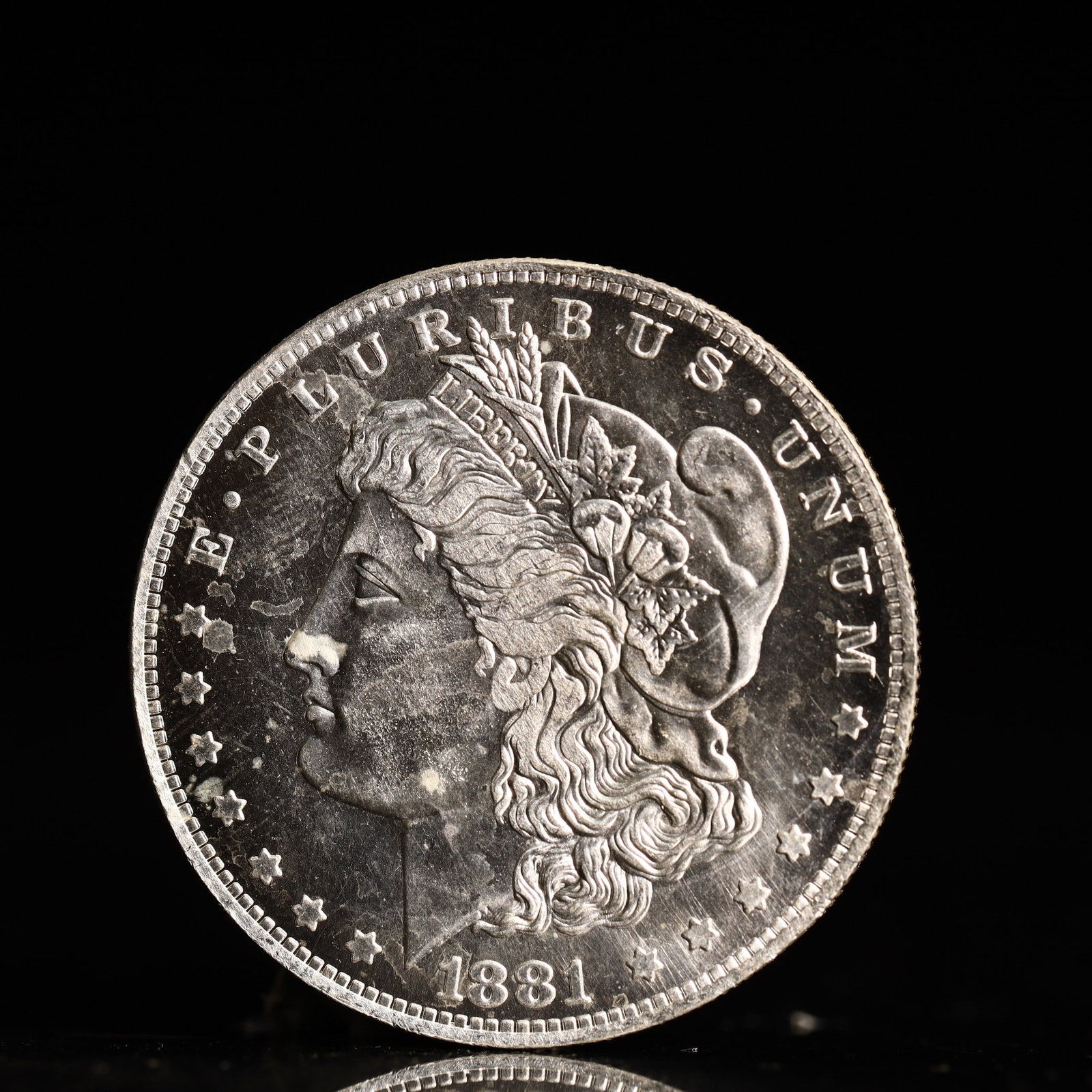 USA Morgan Dollar 1881 Coin: Obv: profile bust with date below and E PLURIBUS UNUM legend and stars around. Rev: eagle with In God we trust above within wreath with UNITED STATES OF AMERICA ONE DOLLAR legend. IN GOD WE TRUST / LI