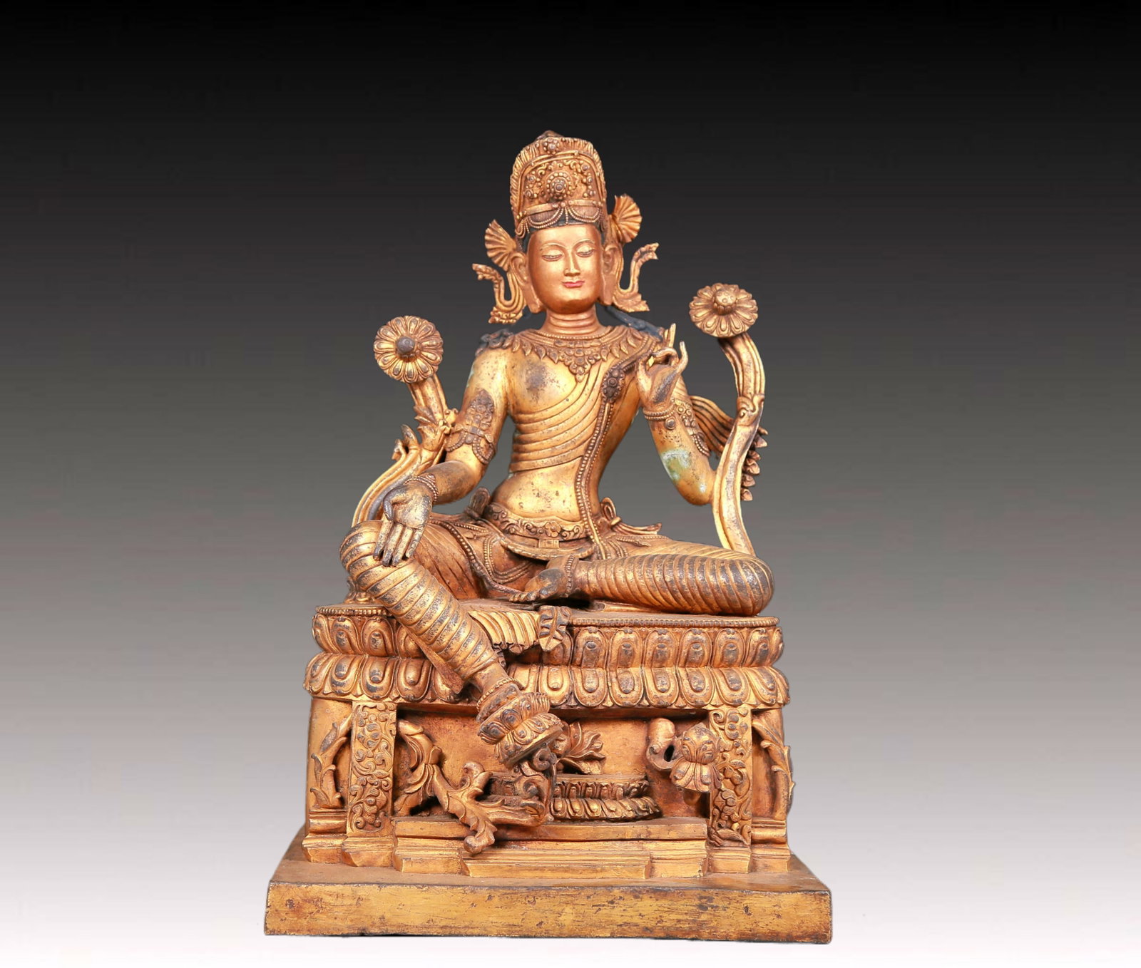 A solemn gilt bronze statue of green Tara: A solemn gilt-bronze green Tara statue with inscription,Ming Dynasty,China. Tara's posture is elegant,with a peaceful and compassionate expression. Her face is soft and A solemn,and her eyes are
