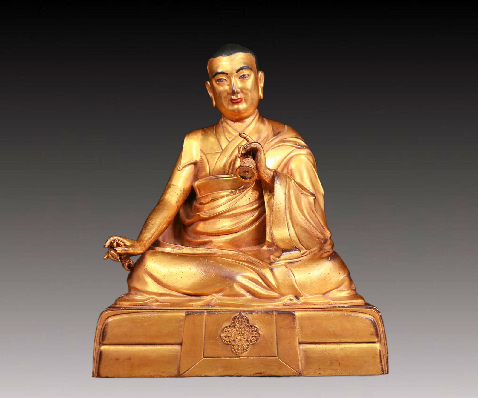 A solemn gilt bronze statue of the master: A solemn gilt bronze statue of the Master,Qianlong mark,Qing Dynasty,China,dressed in traditional monk robes,withA solemn,calm and wise expression on his face,reflecting the Master's compassion and te