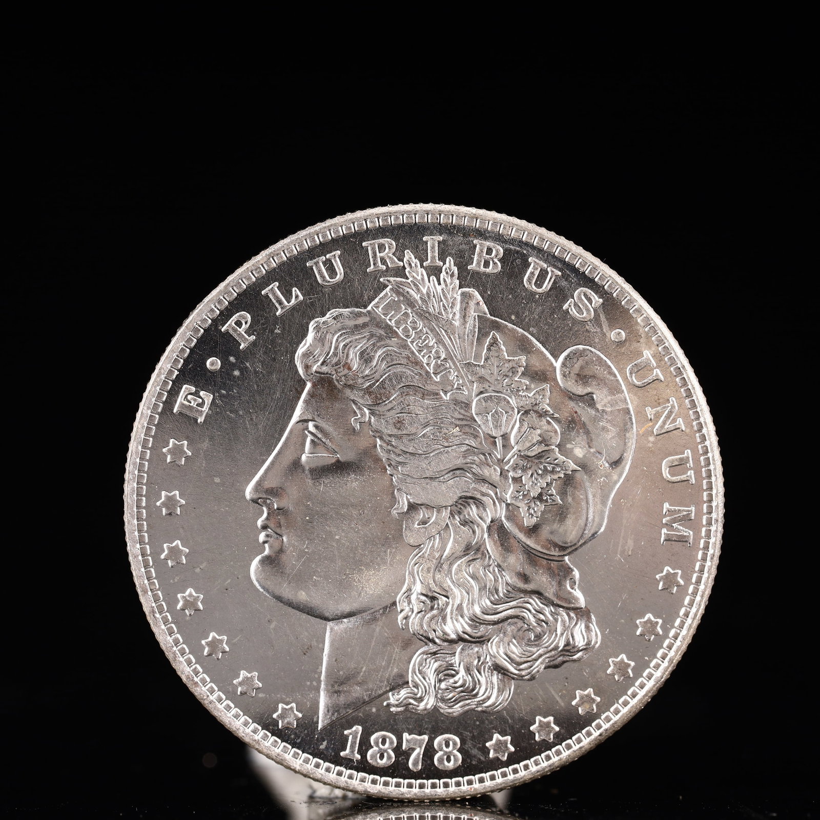 USA Morgan Dollar 1878 Coin: Obv: profile bust with date below and E PLURIBUS UNUM legend and stars around. Rev: eagle with In God we trust above within wreath with UNITED STATES OF AMERICA ONE DOLLAR legend. IN GOD WE TRUST / LI