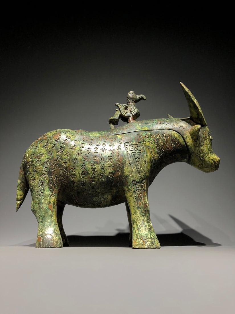 An Archaic Bronze Buffalo-Shaped Food Vessel,With Inscription: An Archaic Bronze Buffalo-Shaped Food Vessel,With Inscription,Shang Dynasty, ChinaSize:15inx5.5inx12.6in,Weight:6500g青铜牛形食器,带铭文,中&