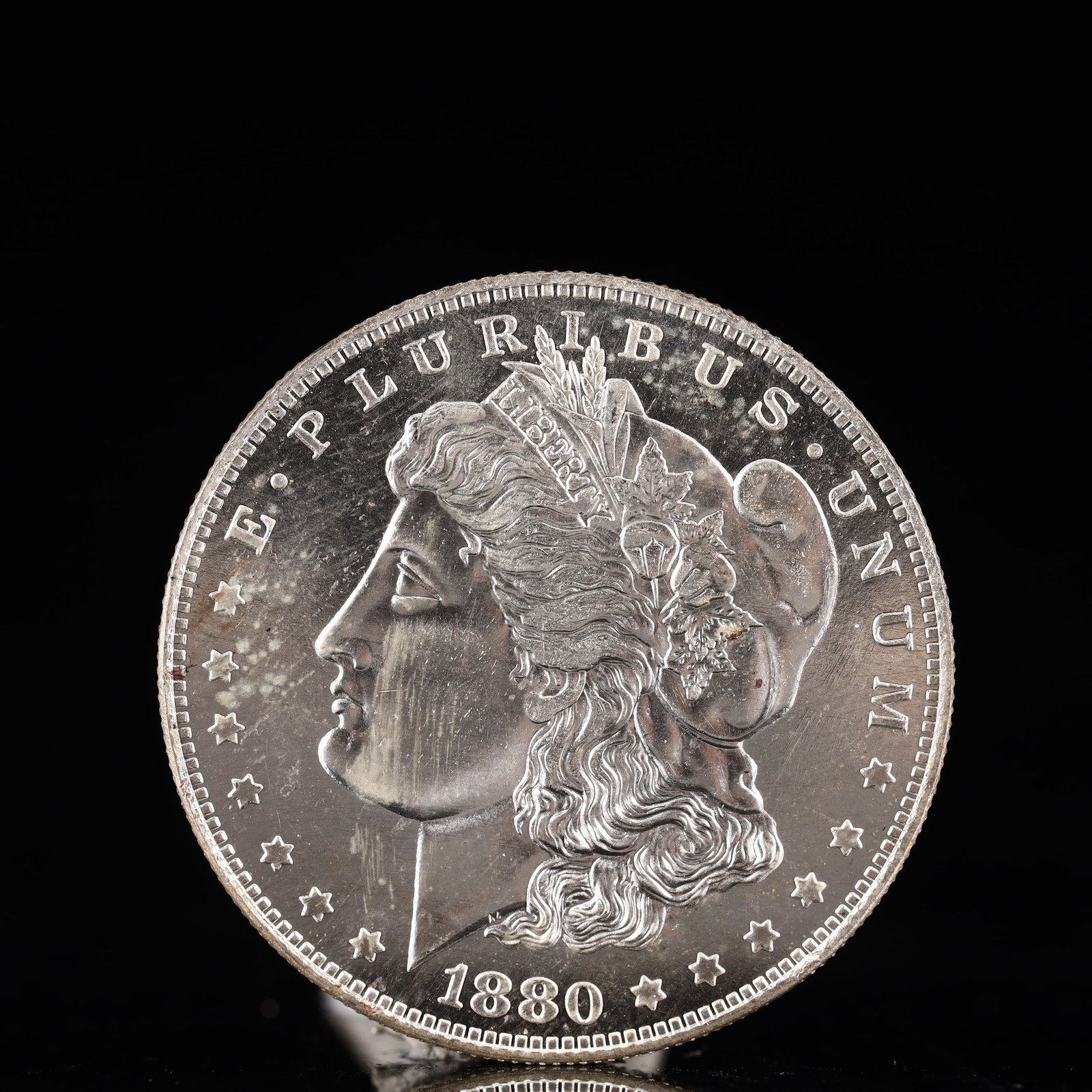 USA Morgan Dollar 1880 Coin: Obv: profile bust with date below and E PLURIBUS UNUM legend and stars around. Rev: eagle with In God we trust above within wreath with UNITED STATES OF AMERICA ONE DOLLAR legend. IN GOD WE TRUST /