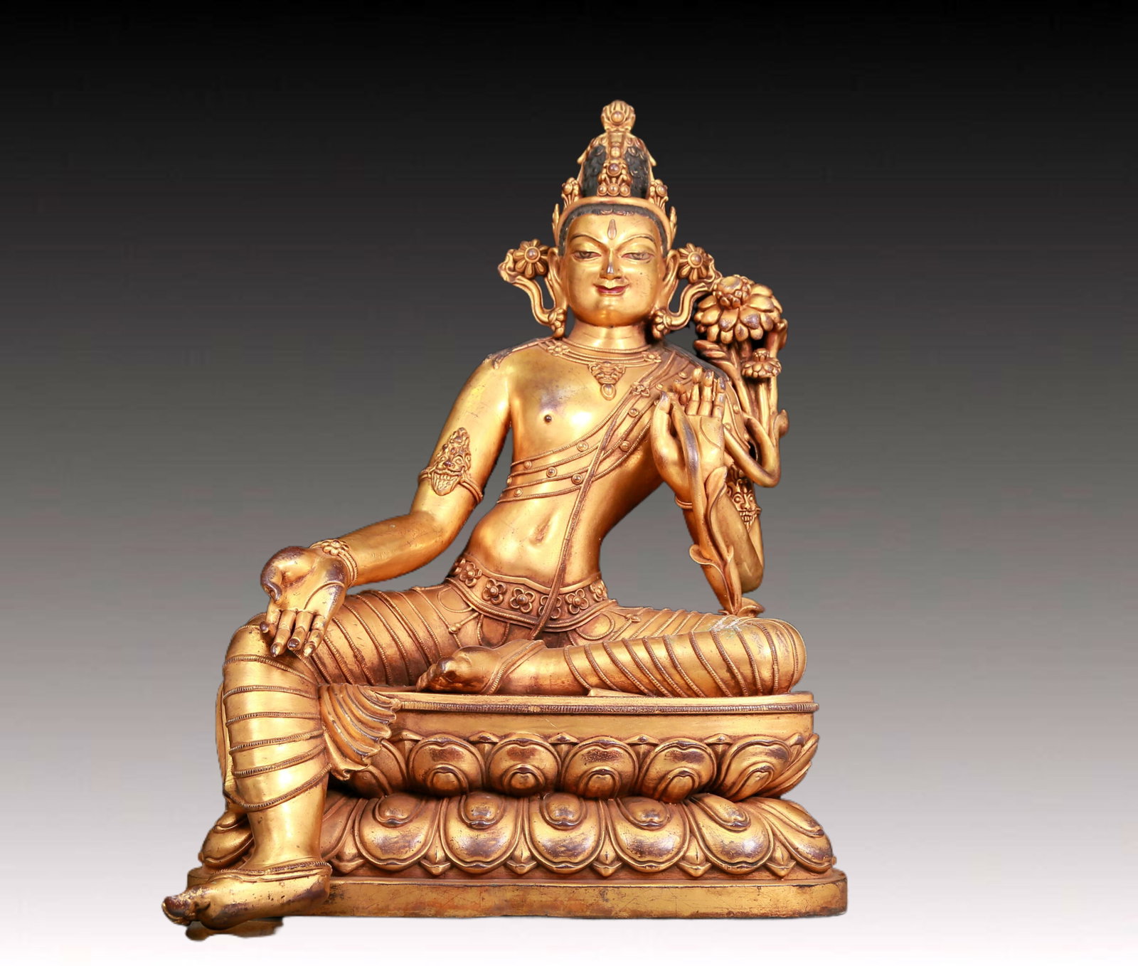 A solemn gilt bronze statue of green Tara: A solemn gilt-bronze green Tara statue,Ming Dynasty,China. Tara has an elegant posture with a peaceful and compassionate expression. Her face is soft and A solemn,and her eyes are warm. She seems to b