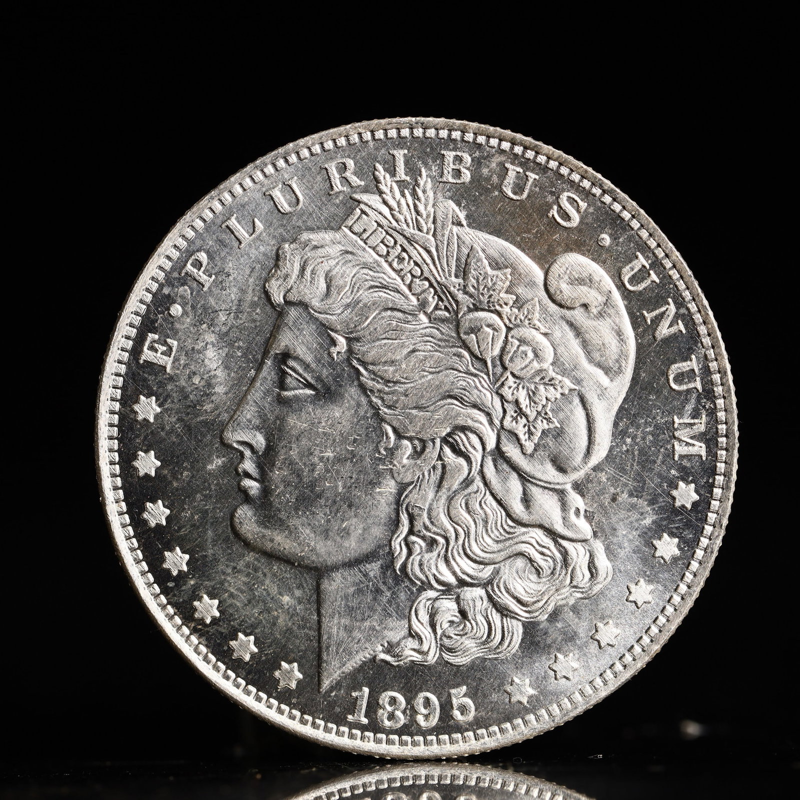 USA Morgan Dollar 1895 Coin: Obv: profile bust with date below and E PLURIBUS UNUM legend and stars around. Rev: eagle with In God we trust above within wreath with UNITED STATES OF AMERICA ONE DOLLAR legend. IN GOD WE TRUST / LI