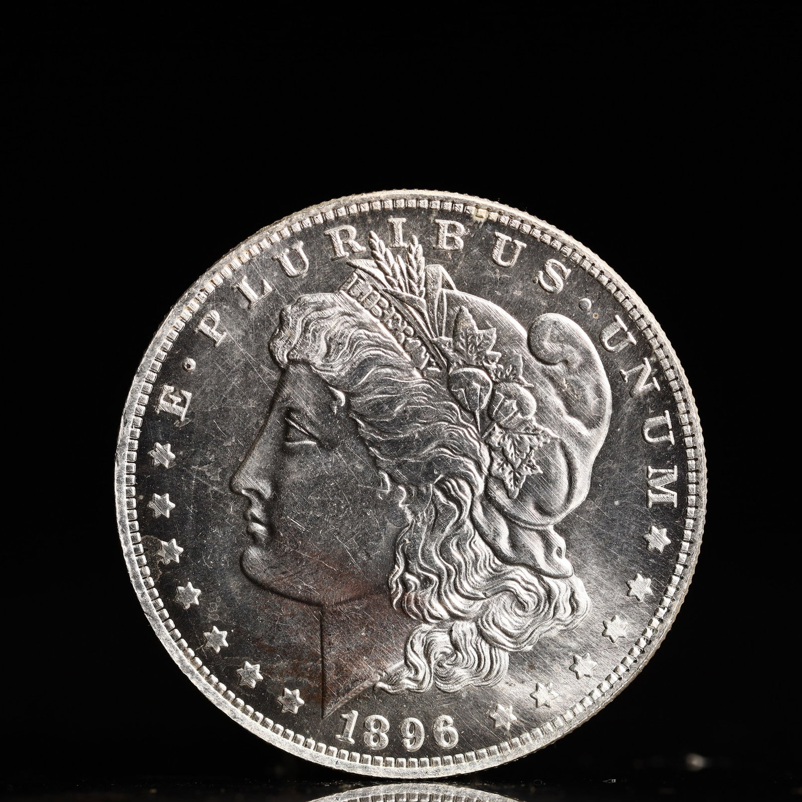 USA Morgan Dollar 1896 Coin: Obv: profile bust with date below and E PLURIBUS UNUM legend and stars around. Rev: eagle with In God we trust above within wreath with UNITED STATES OF AMERICA ONE DOLLAR legend. IN GOD WE TRUST / LI
